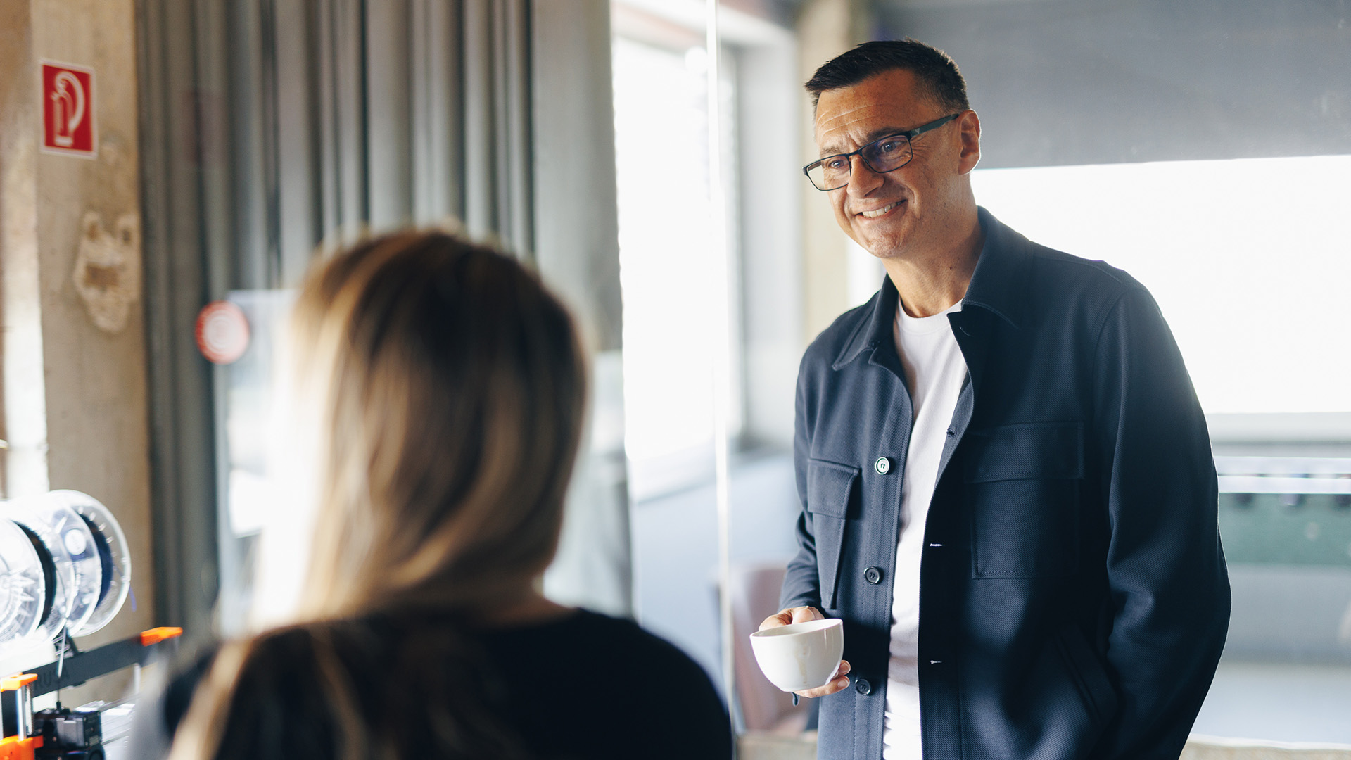 Allister with a cup of coffee chatting with a client