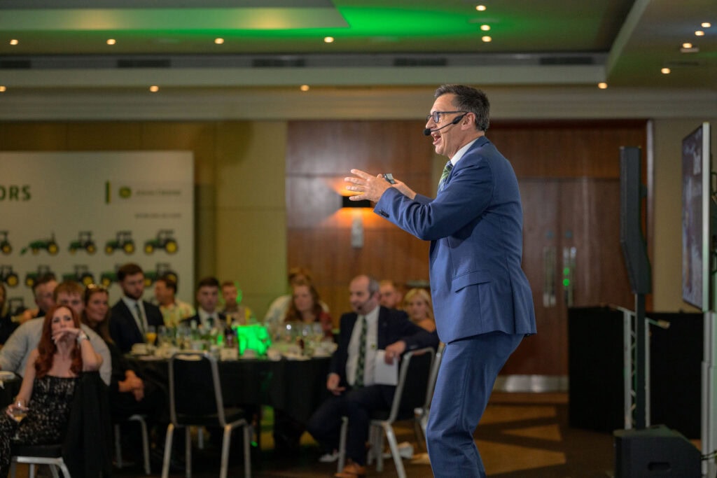 Speaker giving a presentation to an engaged audience in a conference room.
